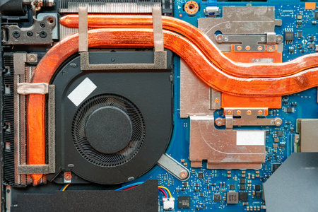 Disassembled laptop after cleaning the cooler system, Reviving technology, specialist focuses on repairing and cleaning, breathing life into a laptop.の写真素材