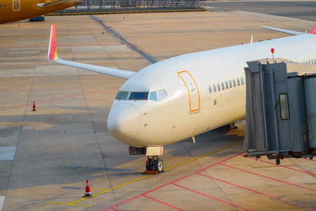 Airplane parked at an airport terminal, a runway in the distance, and other aircraft.の写真素材