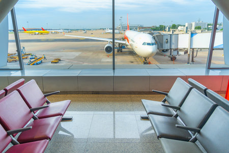 Airport terminal glass window with view of airplane, airport departure hall for travel and transportation conceptの写真素材