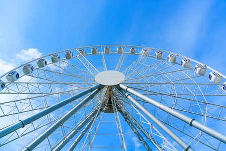 Big tall white ferris wheel in front of perfect blue sky. Happy summer vacation feelings.の写真素材