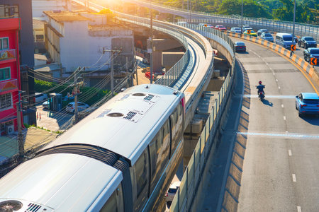 Modern high speed monorail train with bright headlights passes race station on the stage through a...