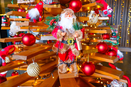 Christmas wooden board tree with New Year toys, Santa Claus balls and lights.の写真素材