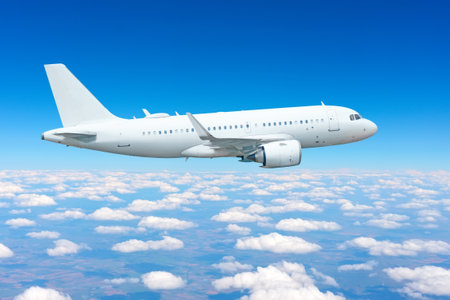 airplane soars gracefully through a bright blue sky, surrounded by fluffy white clouds, capturing the essence of air travel on a clear day.の写真素材