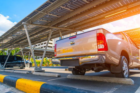 Car parking with canopy roof with solar panels. Solar power generation. Silver metallic pickup car with body.の写真素材