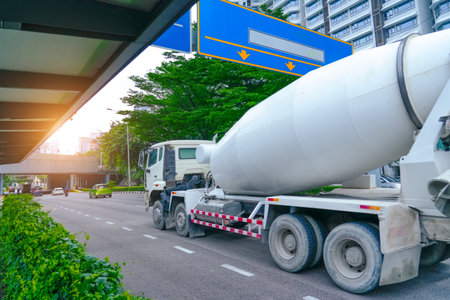 Cement mixer truck driving on highway at junction in city.の写真素材