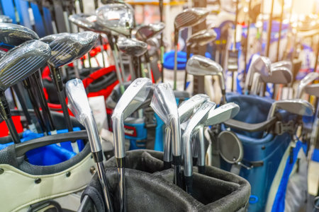 Golf sticks and bags for training and playing golf, inside the club. Equipment and inventory store shop, showcase, sale.の写真素材
