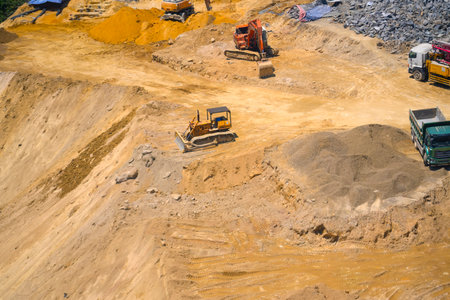 Aerial view directly above an industrial dumper truck or earth mover vehicle with muddy soil and...