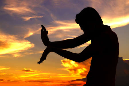 Silhouette of a guy posing with a attacking moveの写真素材