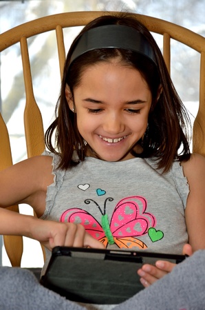 Little Hispanic girl enjoys her new tabletの写真素材