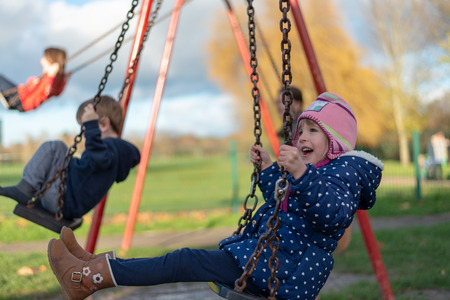 Child on the swing in the playgroundの写真素材
