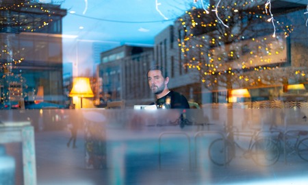 Handsome man with beard in coffee shop with lights reflectingの写真素材
