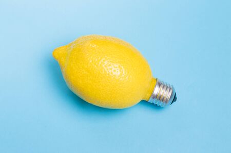 lemon in the form of a light bulb on a blue backgroundの写真素材
