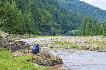backpack with a solar panel on the background of the riverの写真素材