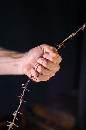 hand holds rusty barbed wireの写真素材