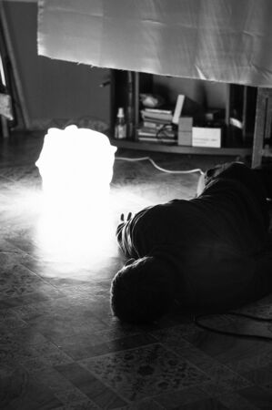 a man lies in the middle of a room on the floorの写真素材