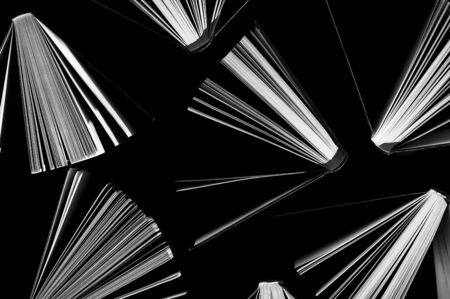 top view of half-opened books on black backgroundの写真素材