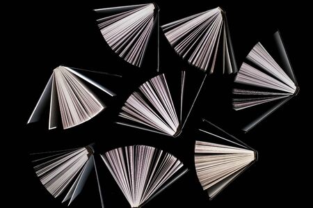 top view of half-opened books on black backgroundの写真素材