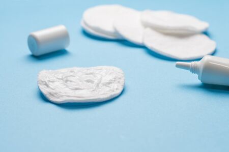 cream and cotton pads on a blue backgroundの写真素材