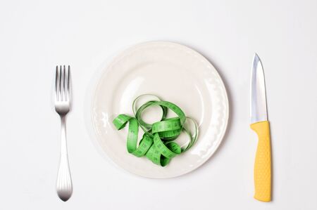 knife and fork near on a plate, on the meter plate, the concept of losing weightの写真素材
