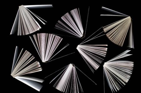top view of half-opened books on black backgroundの写真素材