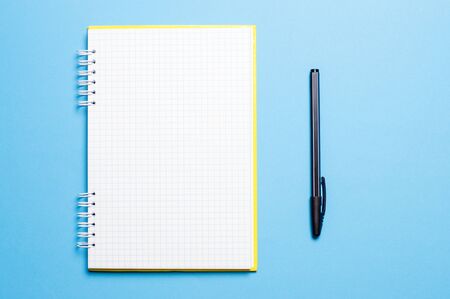 notebook on a blue background with pens