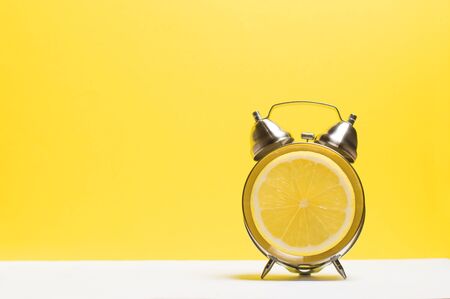 watch on a yellow background with a lemon instead of a dialの写真素材