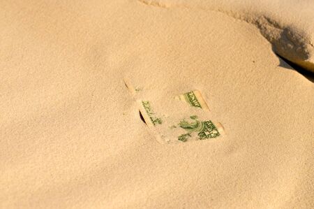 banknote covered with sandの写真素材
