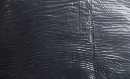 crumpled glossy dark polyethylene textureの写真素材