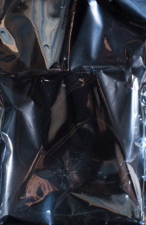 dark glossy crumpled polyethylene backgroundの写真素材