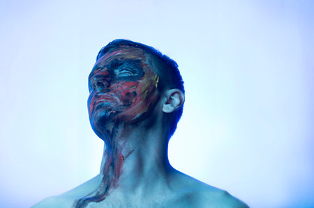 portrait of a guy, his face is drenched in dark colorsの写真素材