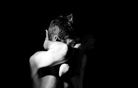 dramatic portrait of a guy, hands in the faceの写真素材