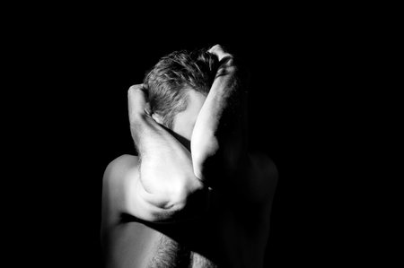 dramatic portrait of a guy, hands in the face