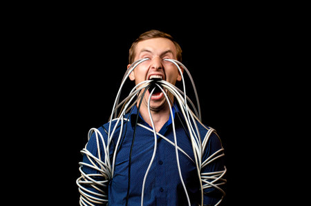 a man in a shirt wrapped the wires, the wires go out of his mouthの写真素材