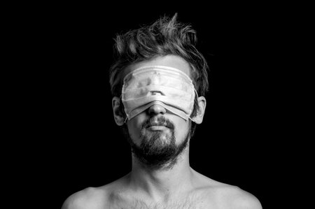 portrait of a guy on a black background, a mask on his eyesの写真素材