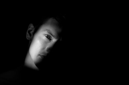 dramatic portrait of a man on black backgroundの写真素材