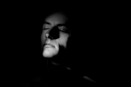 dramatic portrait of a man on black backgroundの写真素材