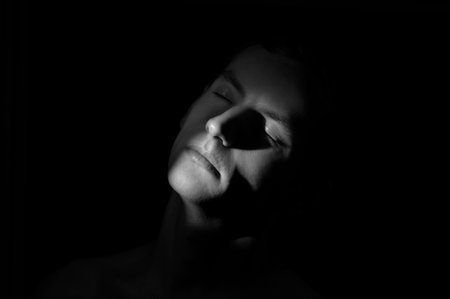dramatic portrait of a man on black backgroundの写真素材