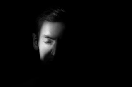 dramatic portrait of a man on black backgroundの写真素材