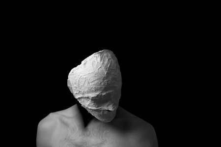 black and white photo of a man in a plaster maskの写真素材