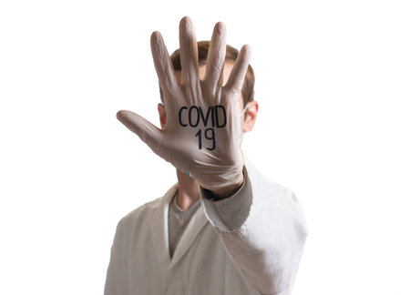 palm in a medical glove in the face with the abbreviation COVID-19の写真素材
