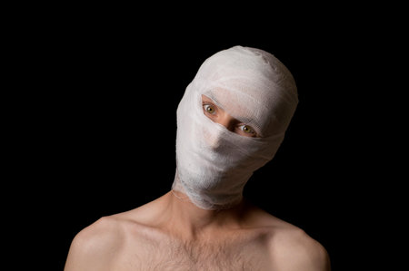 portrait of a guy head wrapped in a bandageの写真素材