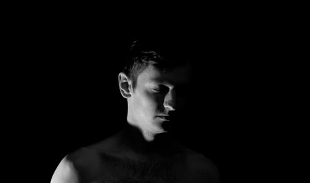 black and white photo portrait of a guy, in dramatic lightingの写真素材