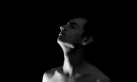 black and white photo portrait of a guy, in dramatic lightingの写真素材