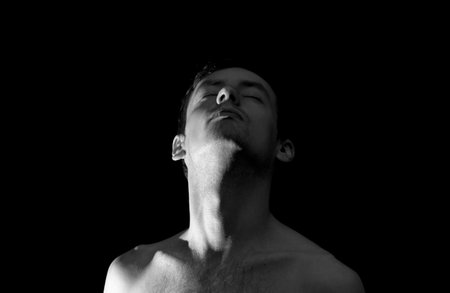 black and white photo portrait of a guy, in dramatic lightingの写真素材