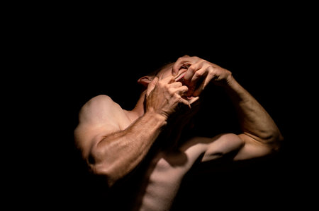 tearing his mouth open with his hands, dramatic photoの写真素材