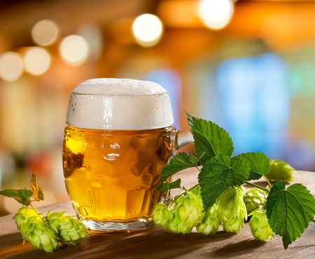still life with glass of beer and hops
