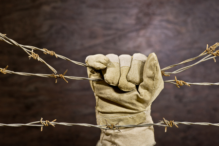 old rusty barbed wire with hand の写真素材