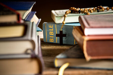 a bible and rosary in the bookcaseの写真素材