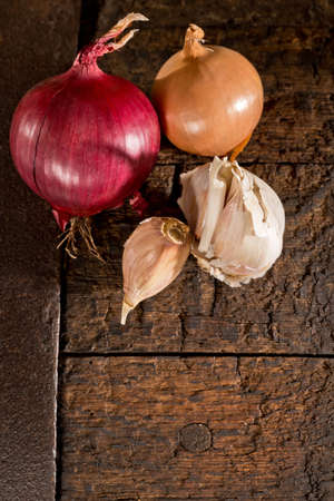 garlic and onion on the old wooden tableの写真素材