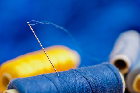 needle and blue and yellow thread on the blue backgroundの写真素材